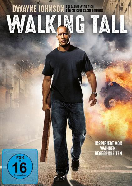 Dwayne Johnson in 'Walking Tall' Filmplakat, Holz haltend. Gebäude und Feuer im Hintergrund.