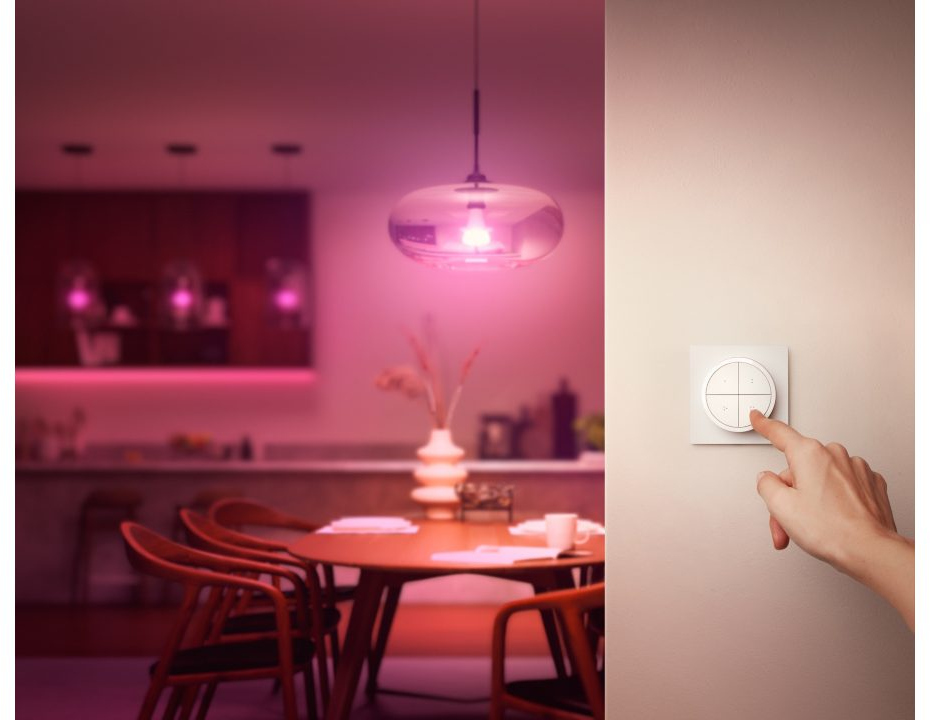 Une main touchant un interrupteur, avec une pièce éclairée en arrière-plan.