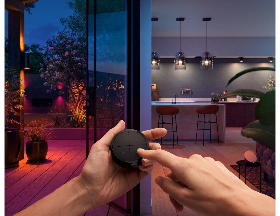 A hand holding a black control panel with a light.