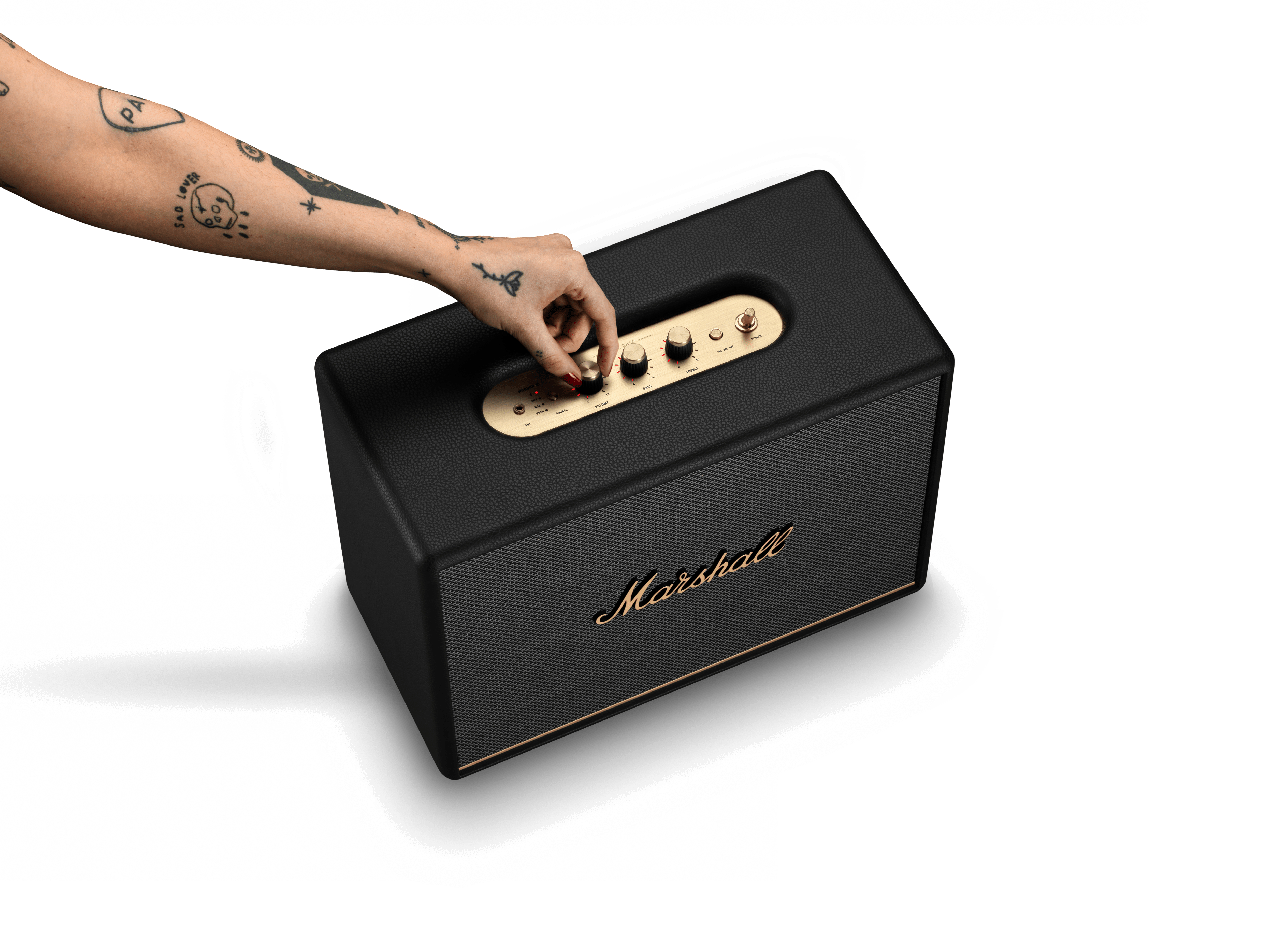 Eine Hand berührt die goldenen Bedienelemente eines schwarzen Marshall-Lautsprechers.