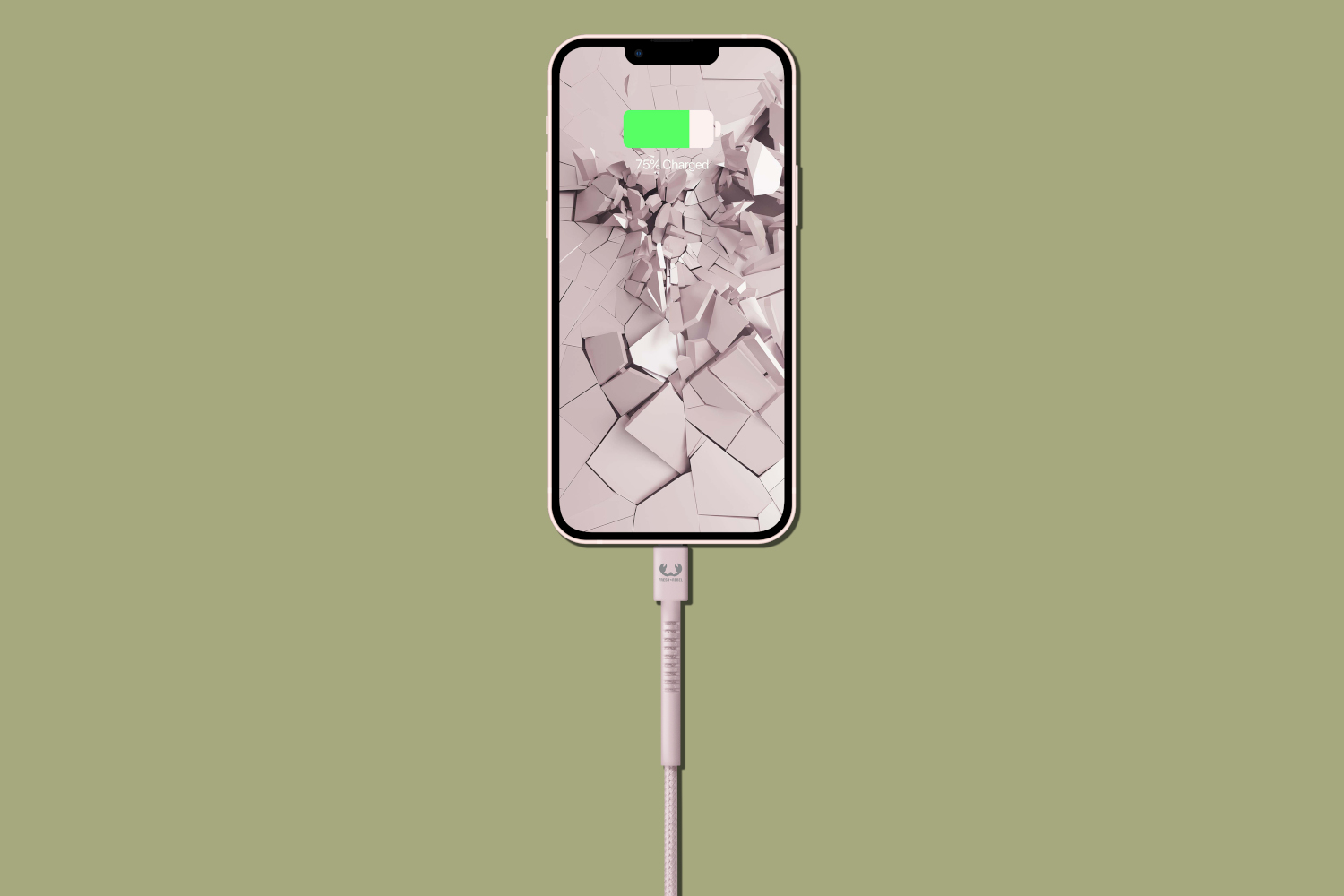 Phone with a cracked screen charging on a green background.