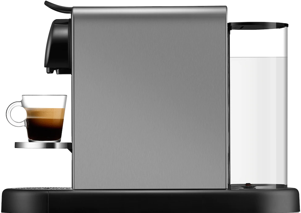 Macchina per espresso argento e nera con un bicchiere di espresso su un vassoio.