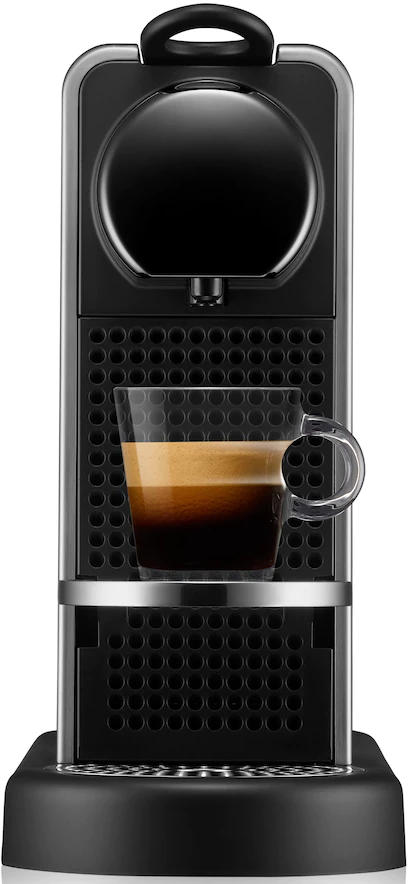 Macchina da caffè Nespresso nera con una tazza di caffè in vetro.
