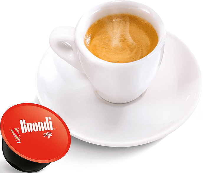 Espresso in tazza bianca su piattino, con una capsula di caffè rossa a lato.