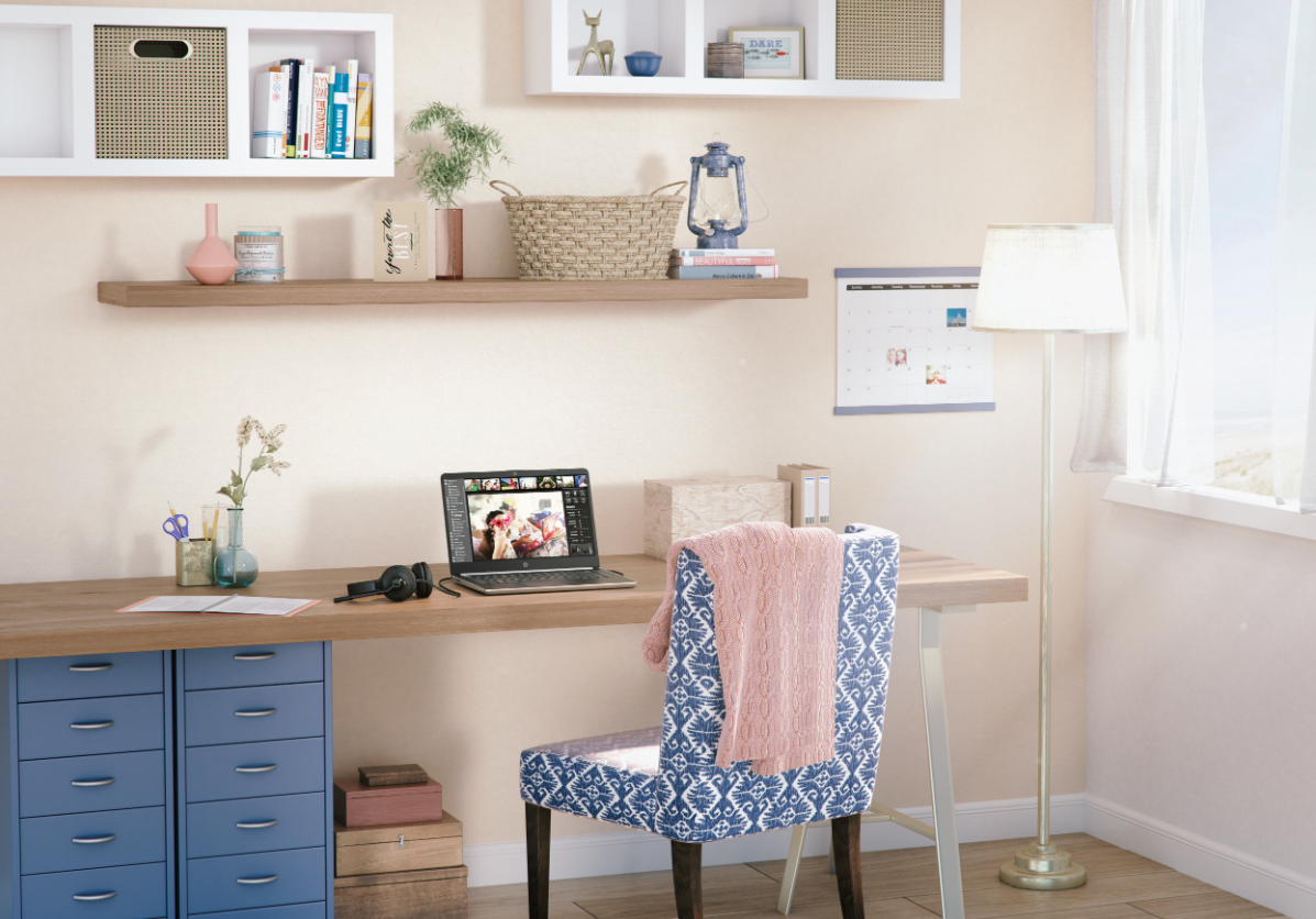 Configuración de oficina en casa con una laptop en un escritorio, libros y una silla estampada. Escena brillante y acogedora.