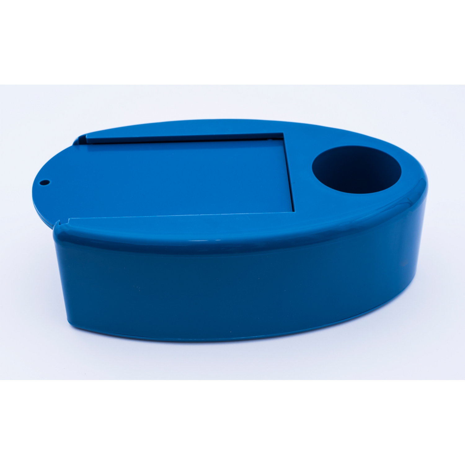 Una bandeja de plástico azul con un recorte rectangular y un agujero circular, sobre una superficie blanca.