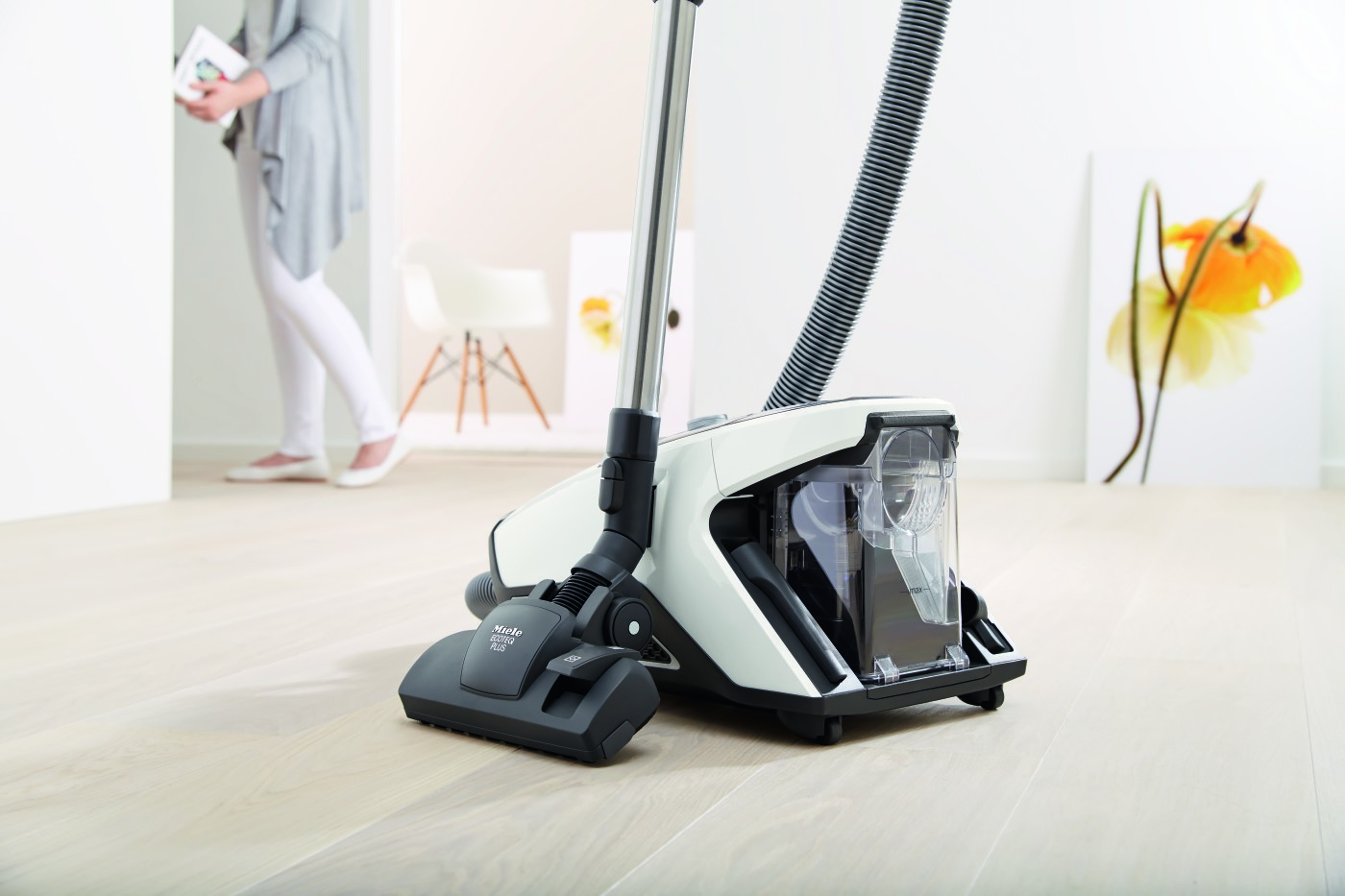 A white and black vacuum cleaner on a wooden floor.