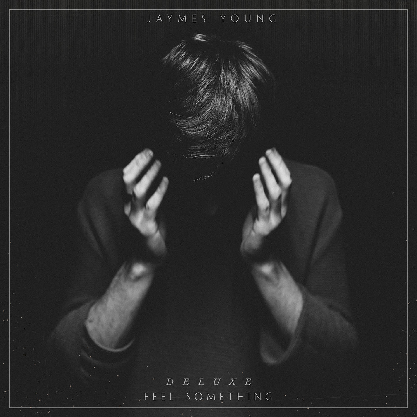 Monokróm albumborító. Egy személy lehajtott fejjel és felemelt kezekkel. A tetején a szöveg: 'JAYMES YOUNG', alul: 'DELUXE FEEL SOMETHING'.