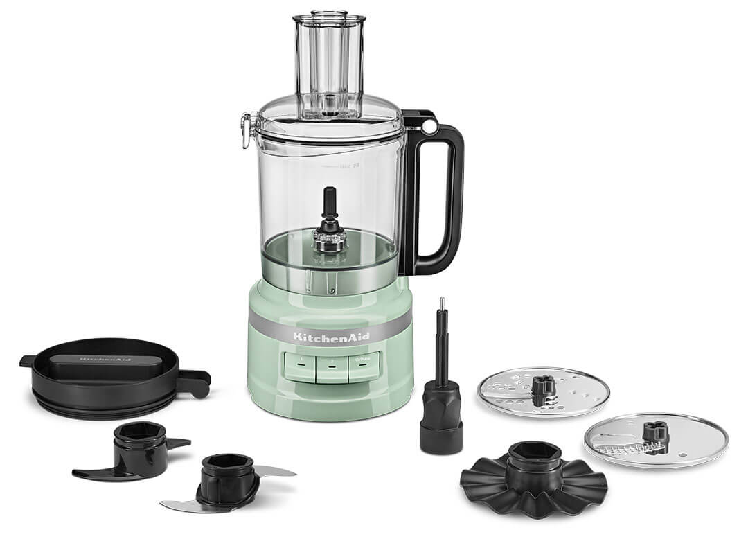 Egy mentazöld KitchenAid konyhai robotgép a különféle tartozékaival, fehér háttér előtt.