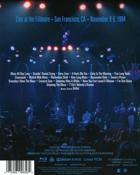 Egy Blu-ray hátlapja. Egy színpadot mutat, ahol egy zenekar játszik, valamint a dalok címeit.