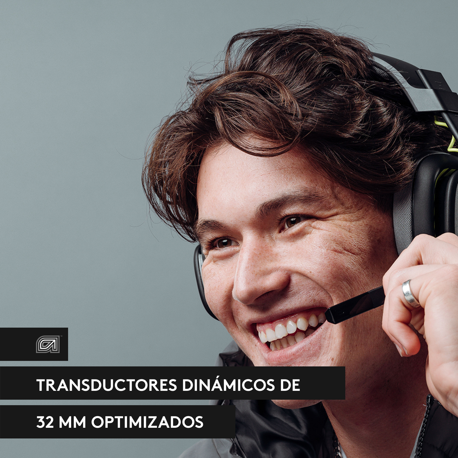 Hombre sonriendo usando auriculares. Texto: Transductores dinámicos optimizados de 32 mm.
