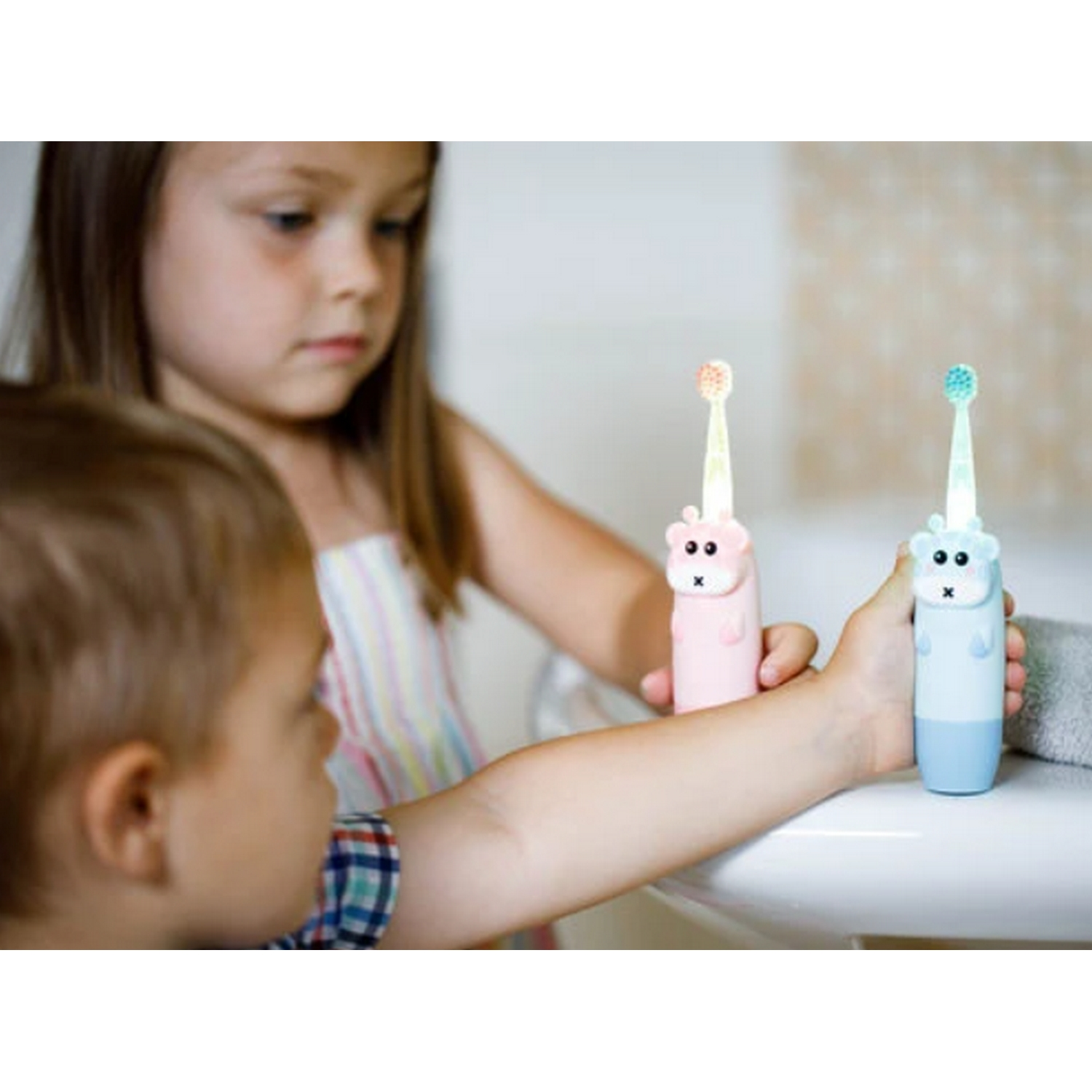 Dos niños cepillándose los dientes con cepillos de dientes con forma de animales en un baño.