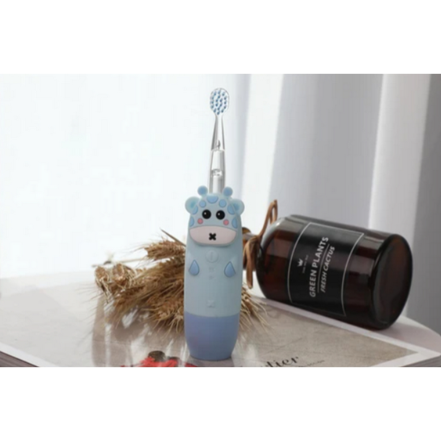 Un cepillo de dientes azul con forma de jirafa y una botella marrón, junto a plantas secas.