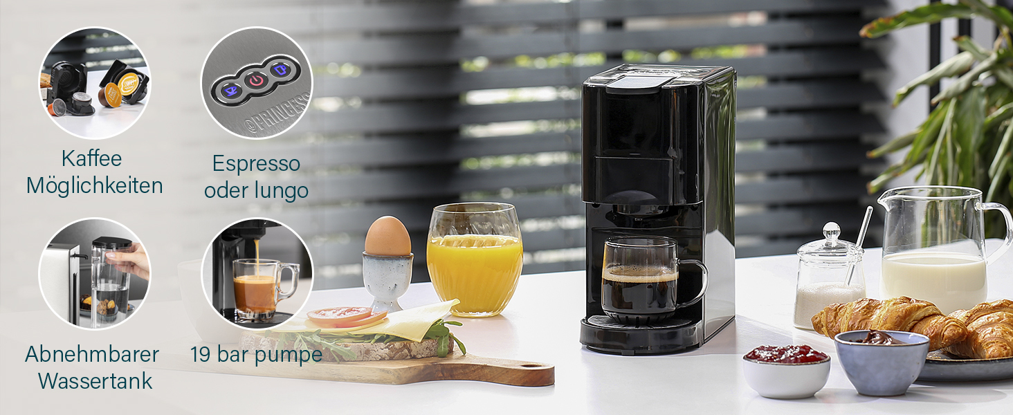 Eine schwarze Kaffeemaschine mit Etiketten. Säfte, Ei und Brot stehen auf dem Tisch.