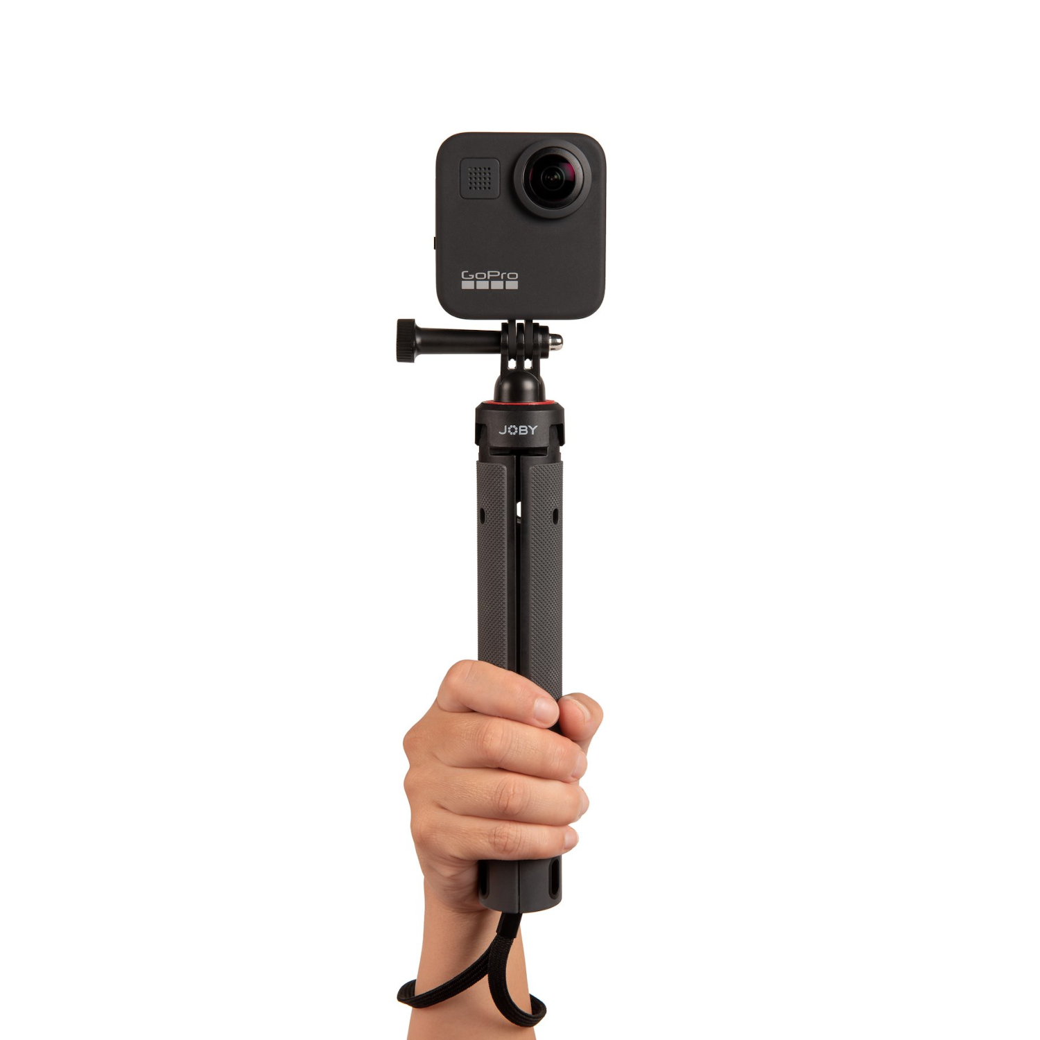 A hand holding a black camera on a small tripod.