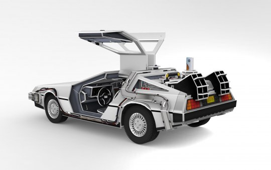 Silbernes DeLorean-Automodell mit geöffneten Türen. Es hat freiliegende Innenteile und einen weißen Hintergrund.