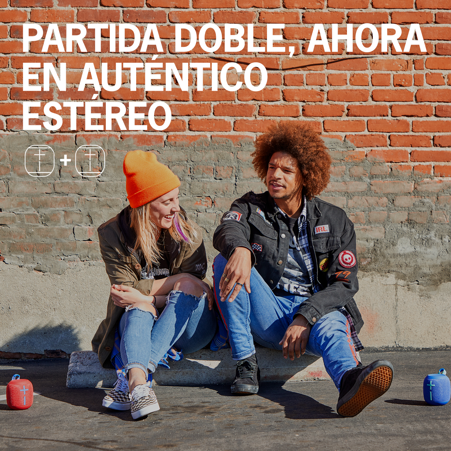 Dos personas sentadas, texto 'Doble juego, ahora en estéreo' y altavoces.