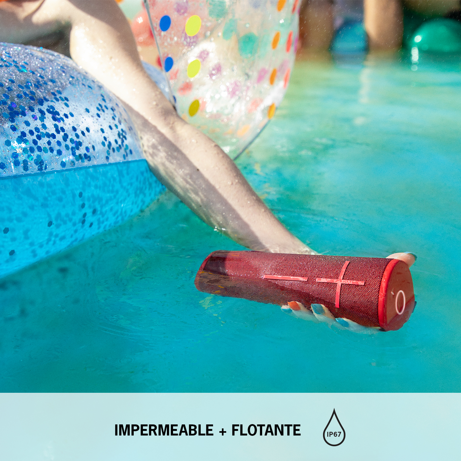 Persona sosteniendo altavoz rojo impermeable en agua azul, con flotador azul.
