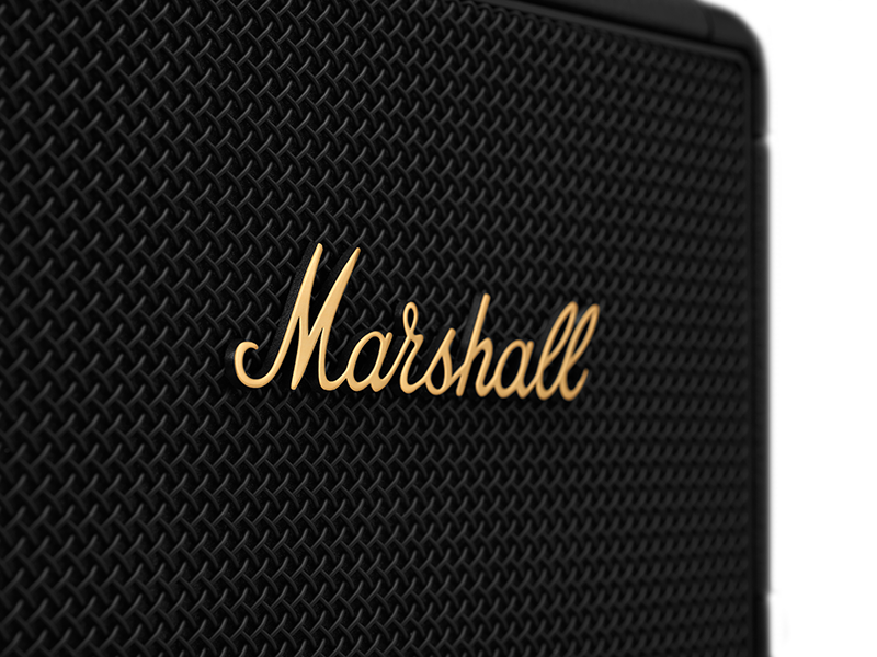 Close-up of a black speaker with a gold 'Marshall' logo.