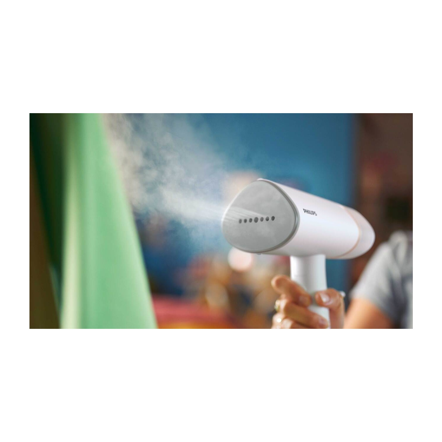 Beyaz ve gümüş renkli bir Philips buharlı pişirici. Bir kişi tarafından tutulurken buhar çıkıyor.