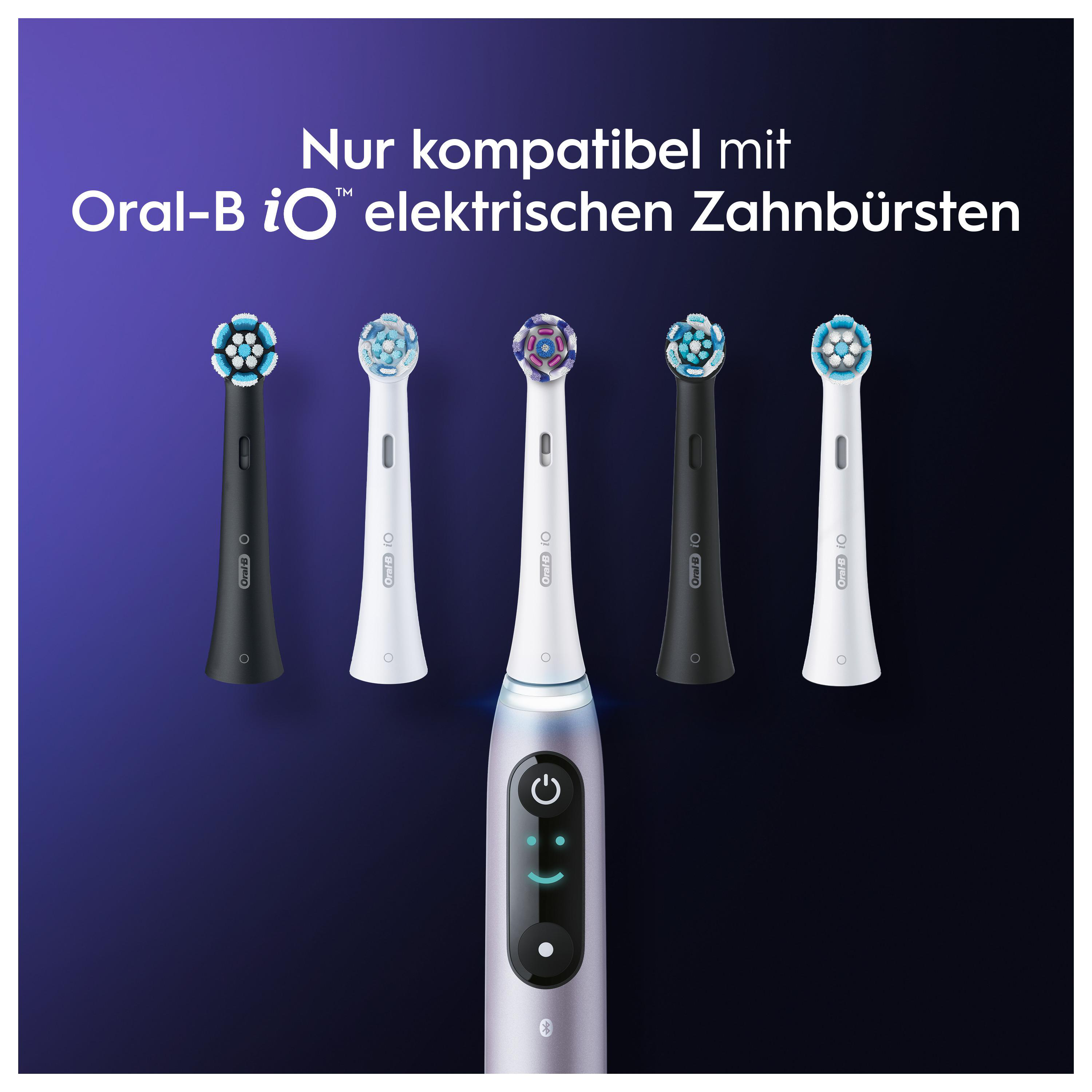 Elektrische Zahnbürste und mehrere Ersatzköpfe. Lila und weiß.
