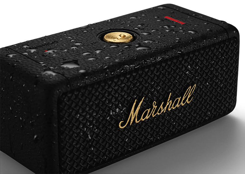 Black portable speaker with gold Marshall logo, water drops visible.