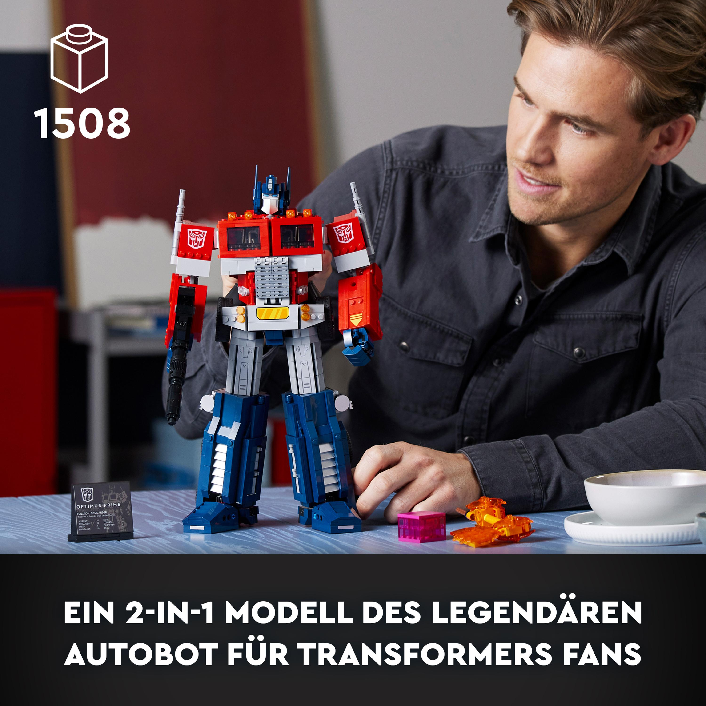 Mann baut einen Lego Optimus Prime. Das Modell und die Teile liegen auf einer blauen Oberfläche.