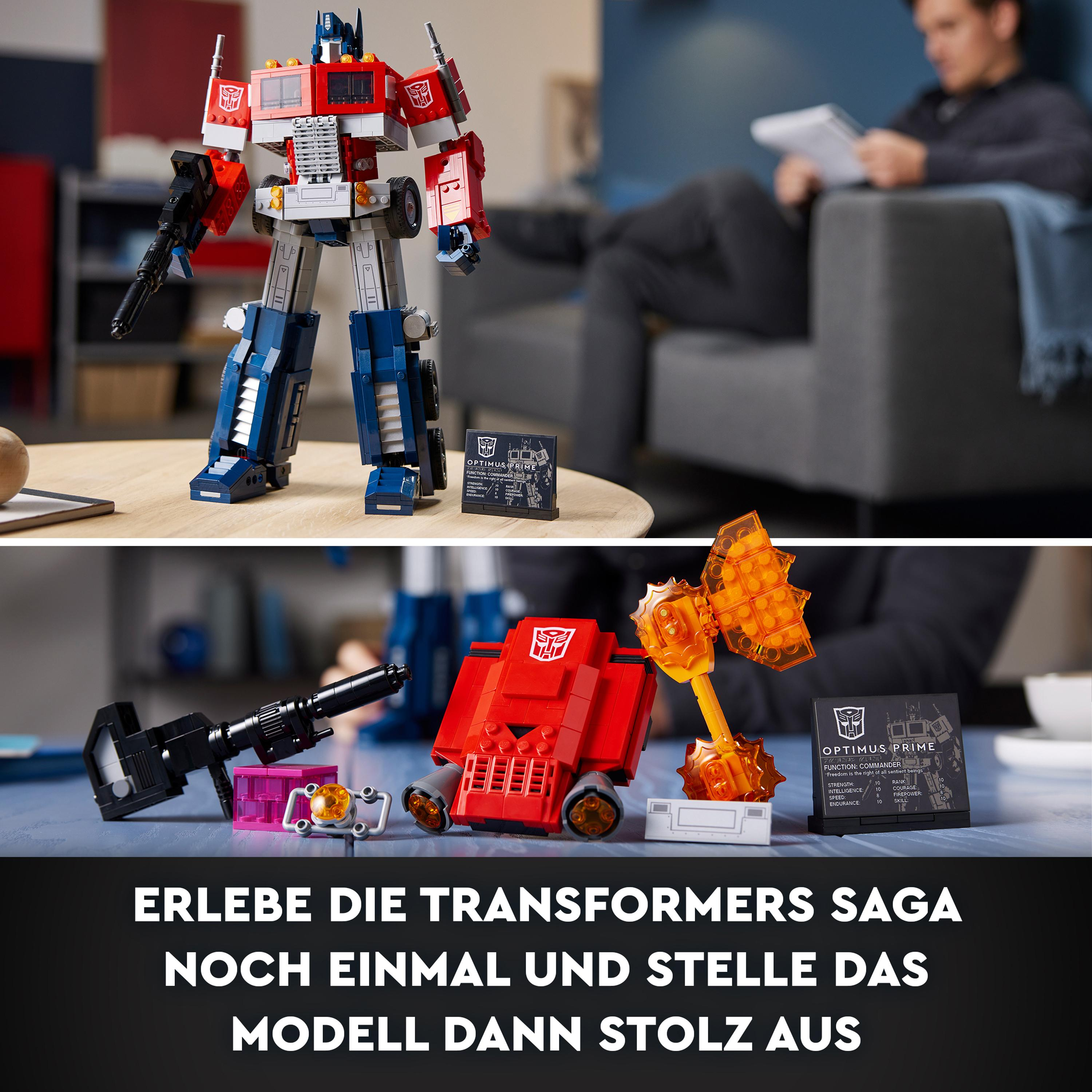 Lego Optimus Prime Figur auf einem Tisch. Eine Person sitzt im Hintergrund.