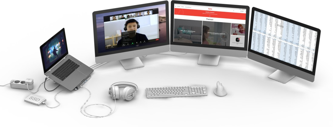 Arbeitsbereich mit Laptop, Monitoren, Tastatur, Maus und Kopfhörern. Weißer Hintergrund.
