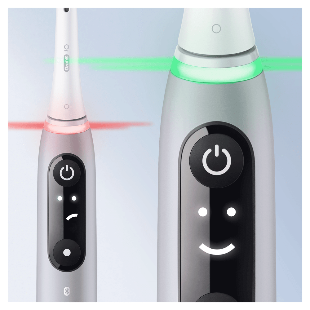 Dos cepillos de dientes eléctricos Oral-B, uno blanco, uno gris, con luces, mostrando diferentes configuraciones.