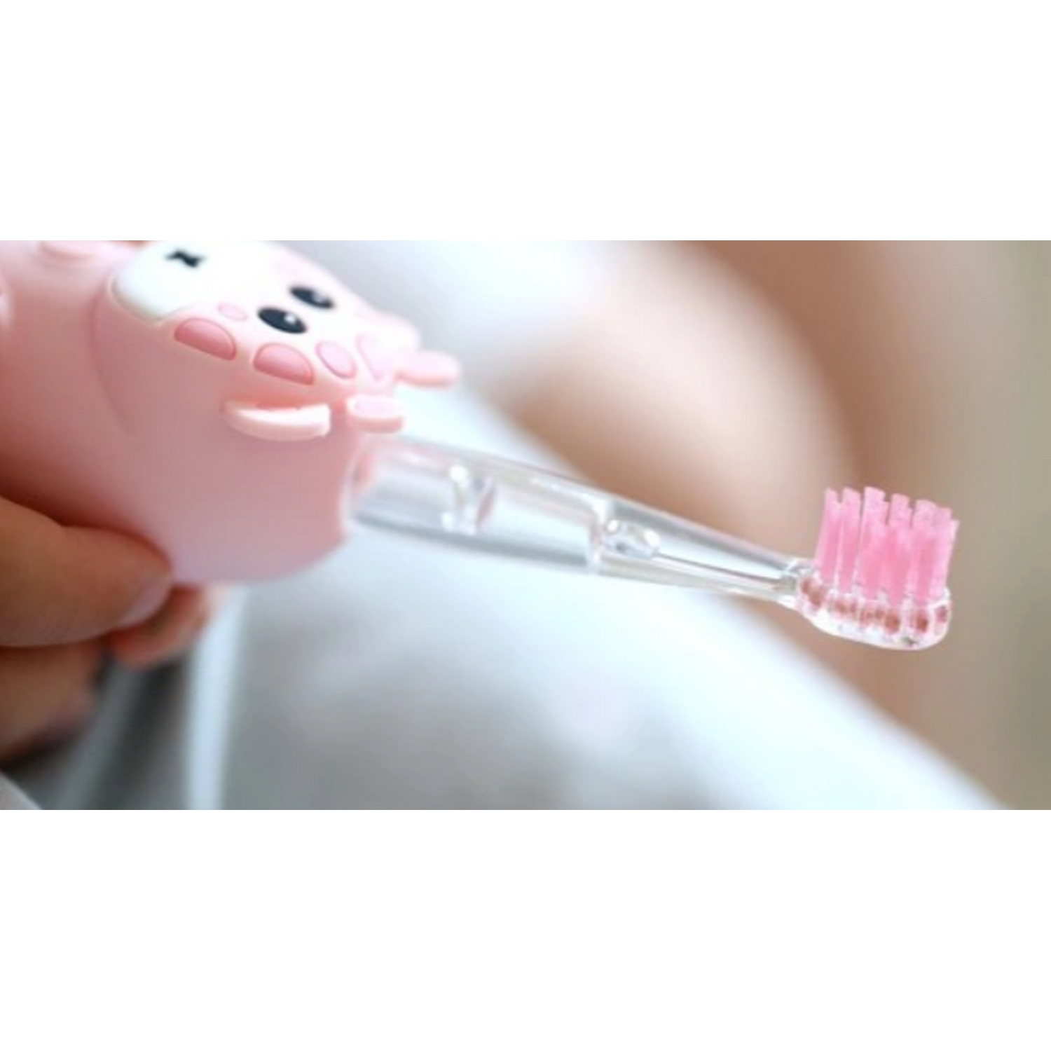 Primer plano de un cepillo de dientes rosa con forma de cerdo y cerdas rosas.