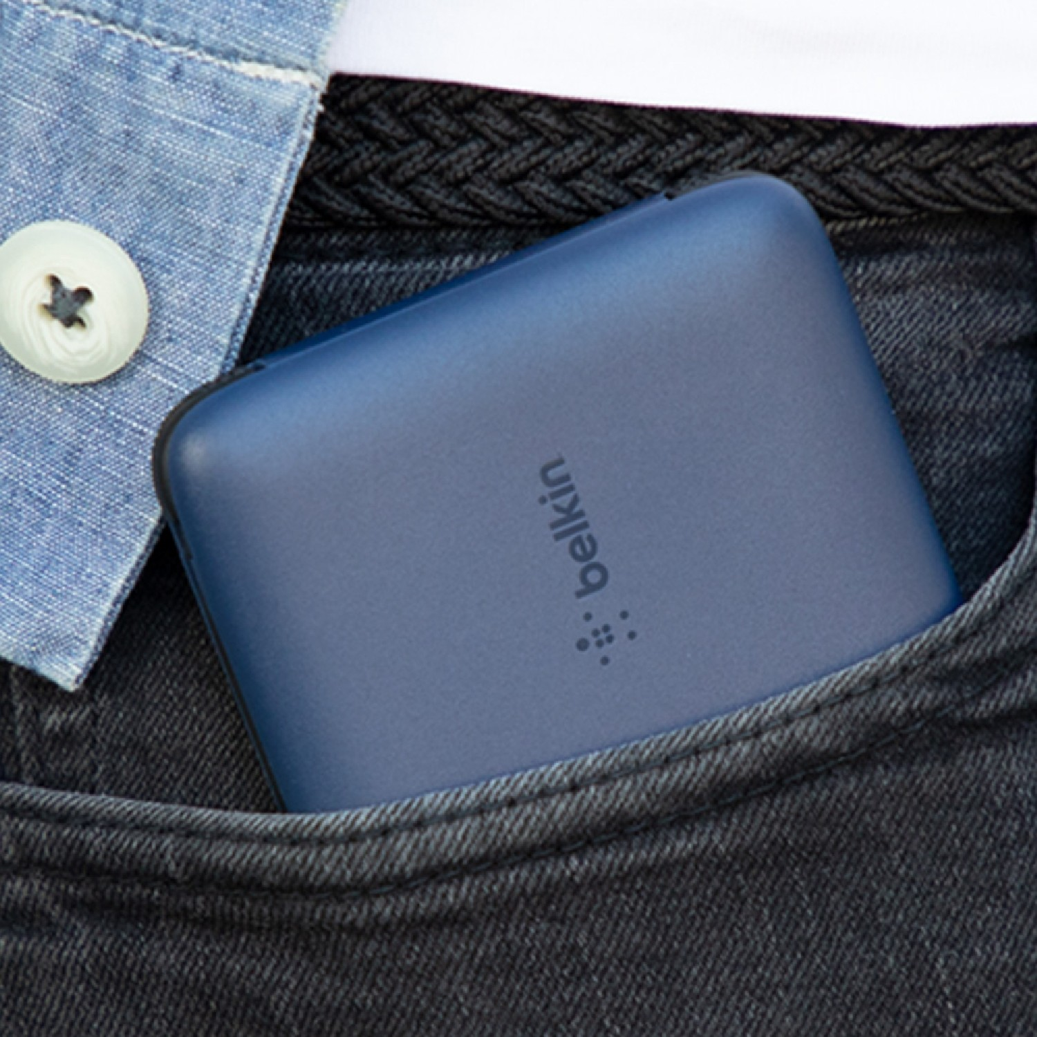 Batería externa Belkin azul en un bolsillo de vaqueros negros.