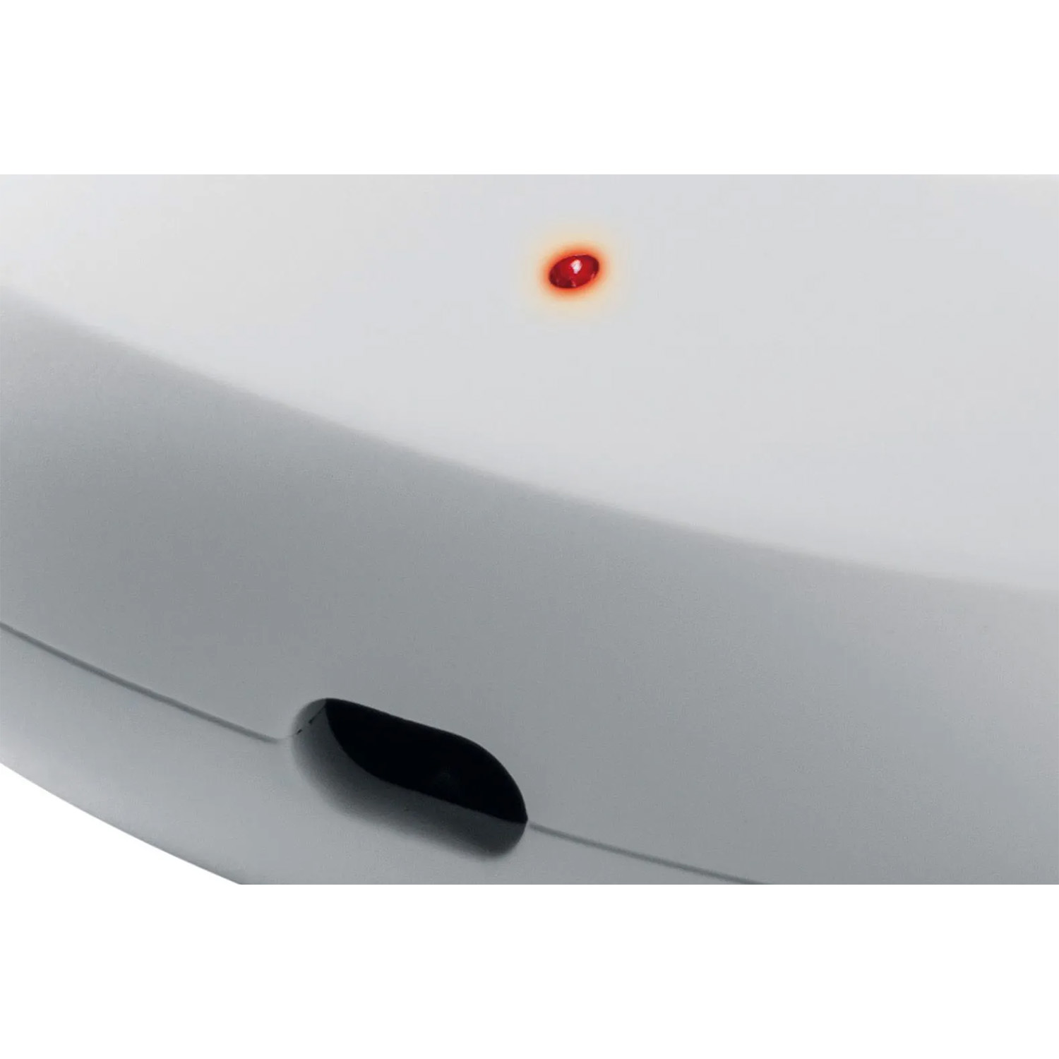 Un primo piano di un dispositivo bianco con un'apertura nera e una luce rossa.