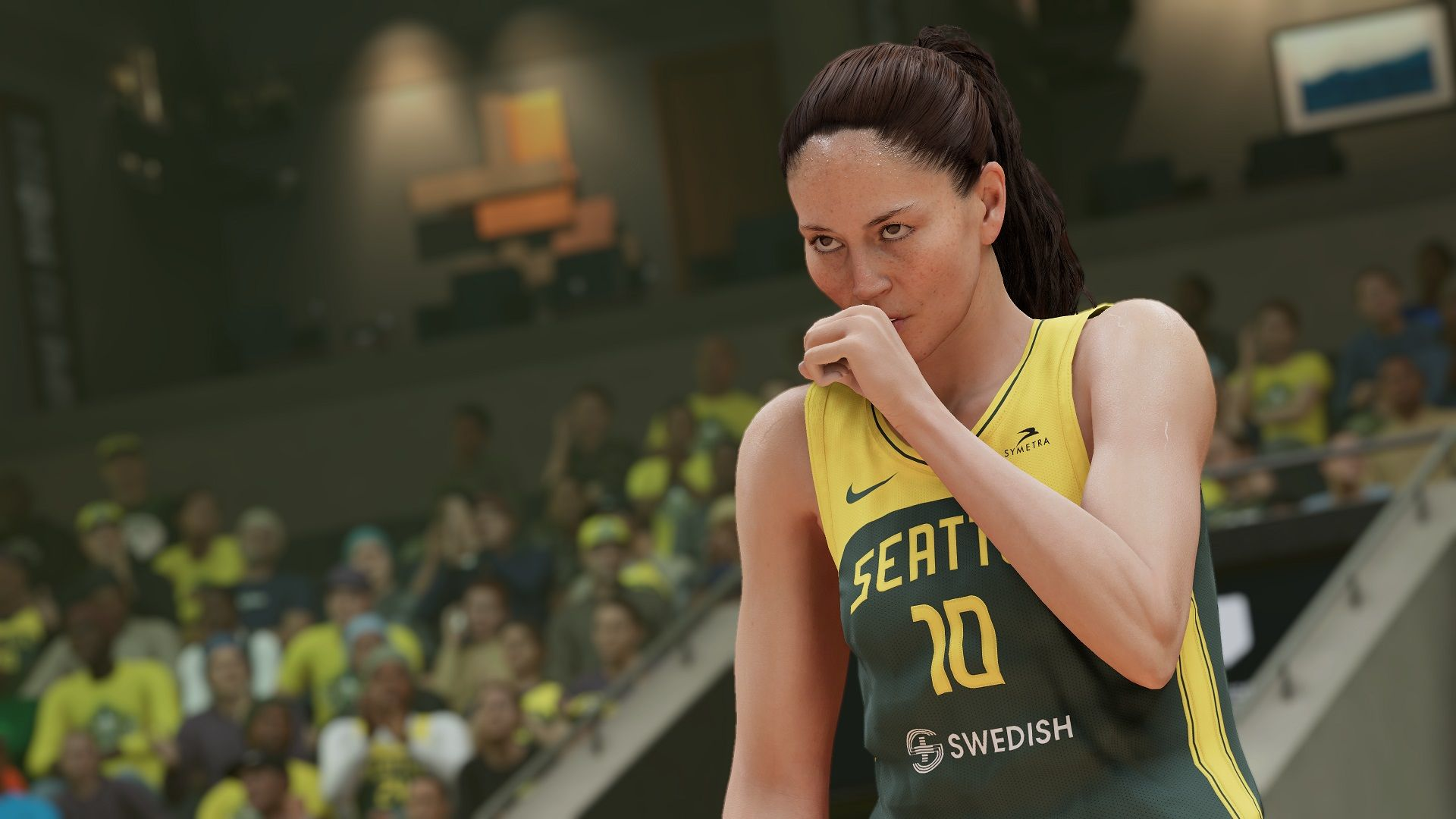 Eine Basketballspielerin im Seattle-Trikot berührt ihren Mund. Die Szene spielt in einem Stadion.