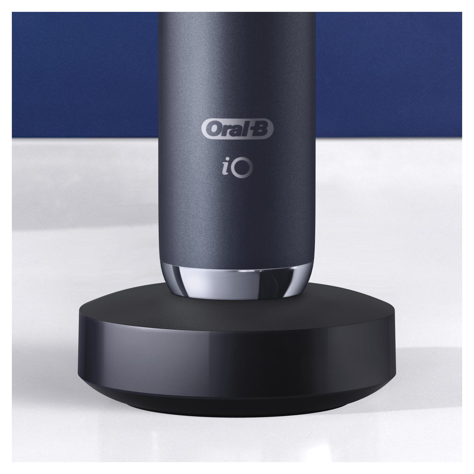 Oral-B iO Zahnbürste auf Ladestation, blauer Hintergrund, weiße Oberfläche.