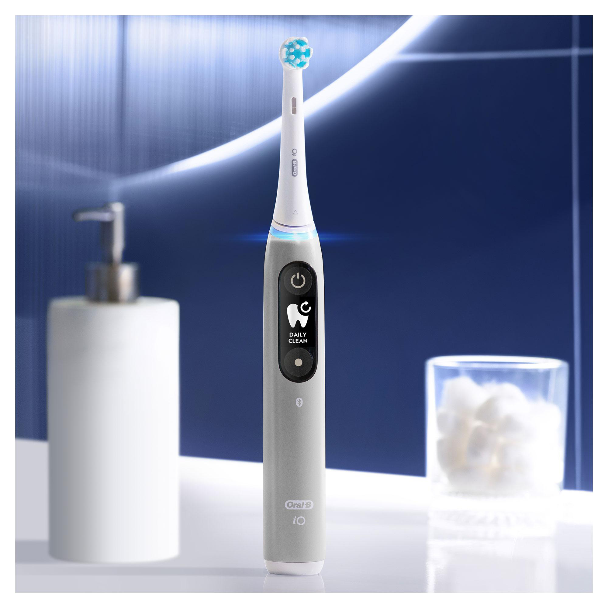 Eine graue elektrische Zahnbürste. Sie hat einen Ein-Aus-Schalter und eine Daily Clean-Anzeige. Ein weißer Hintergrund.