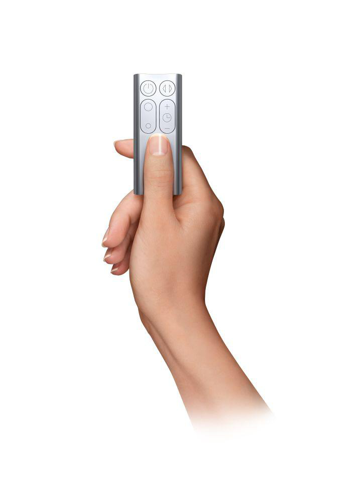 Eine Hand, die eine silberne Dyson-Fernbedienung mit Knöpfen hält, auf weißem Hintergrund.