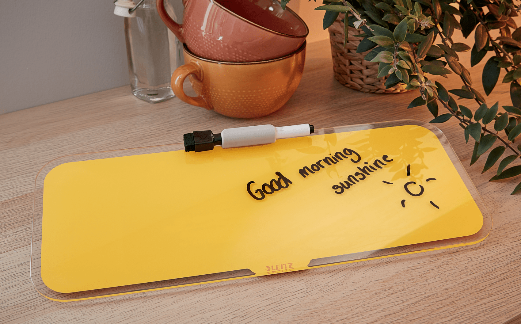 Sárga fehér tábla a 'Good morning sunshine' felirattal, jelölővel és naprajzzal.