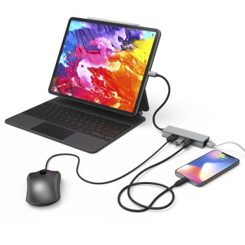 Una tableta con teclado, ratón y teléfono conectados a un concentrador mediante cables.