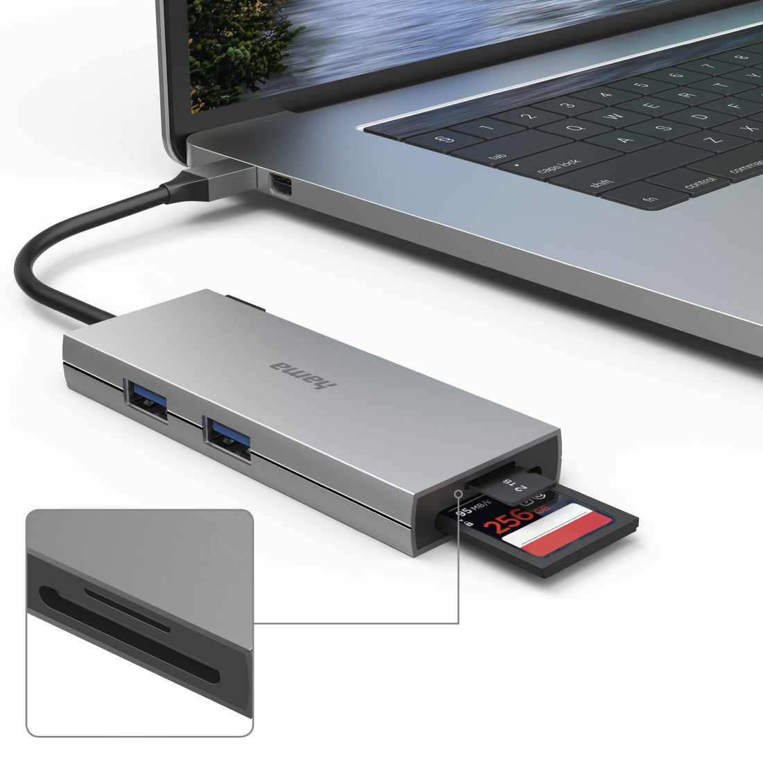 Concentrador USB plateado conectado a un portátil, con tarjeta SD insertada. Primer plano.