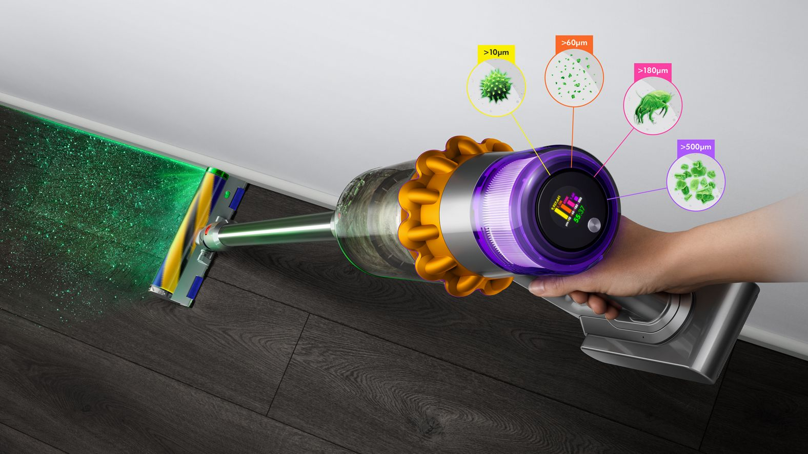 Dyson Akku-Staubsauger reinigt eine Ecke. Zeigt Staubpartikel verschiedener Größen.