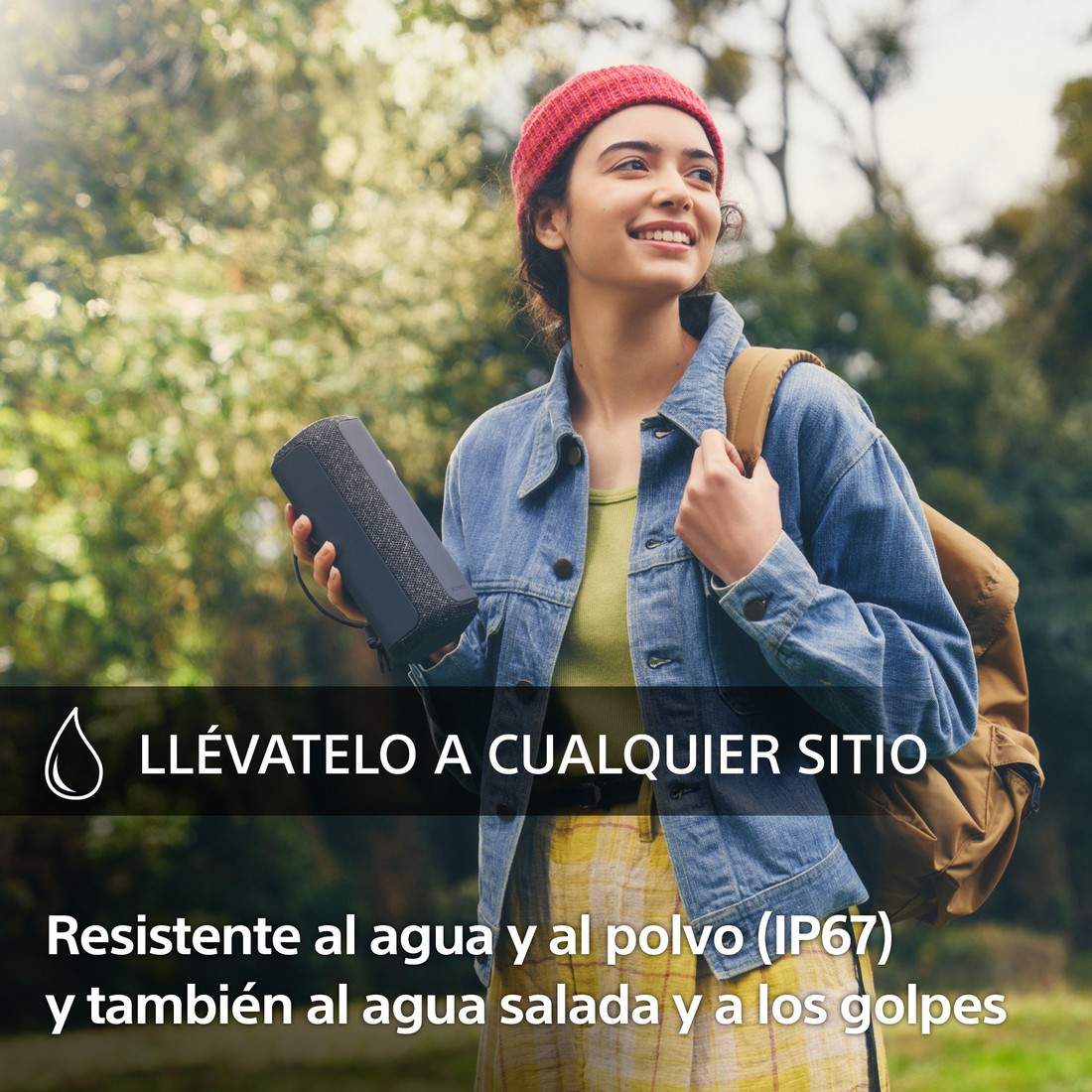 Una mujer sosteniendo un altavoz negro, sonriendo, con texto sobre resistencia al agua y al polvo.