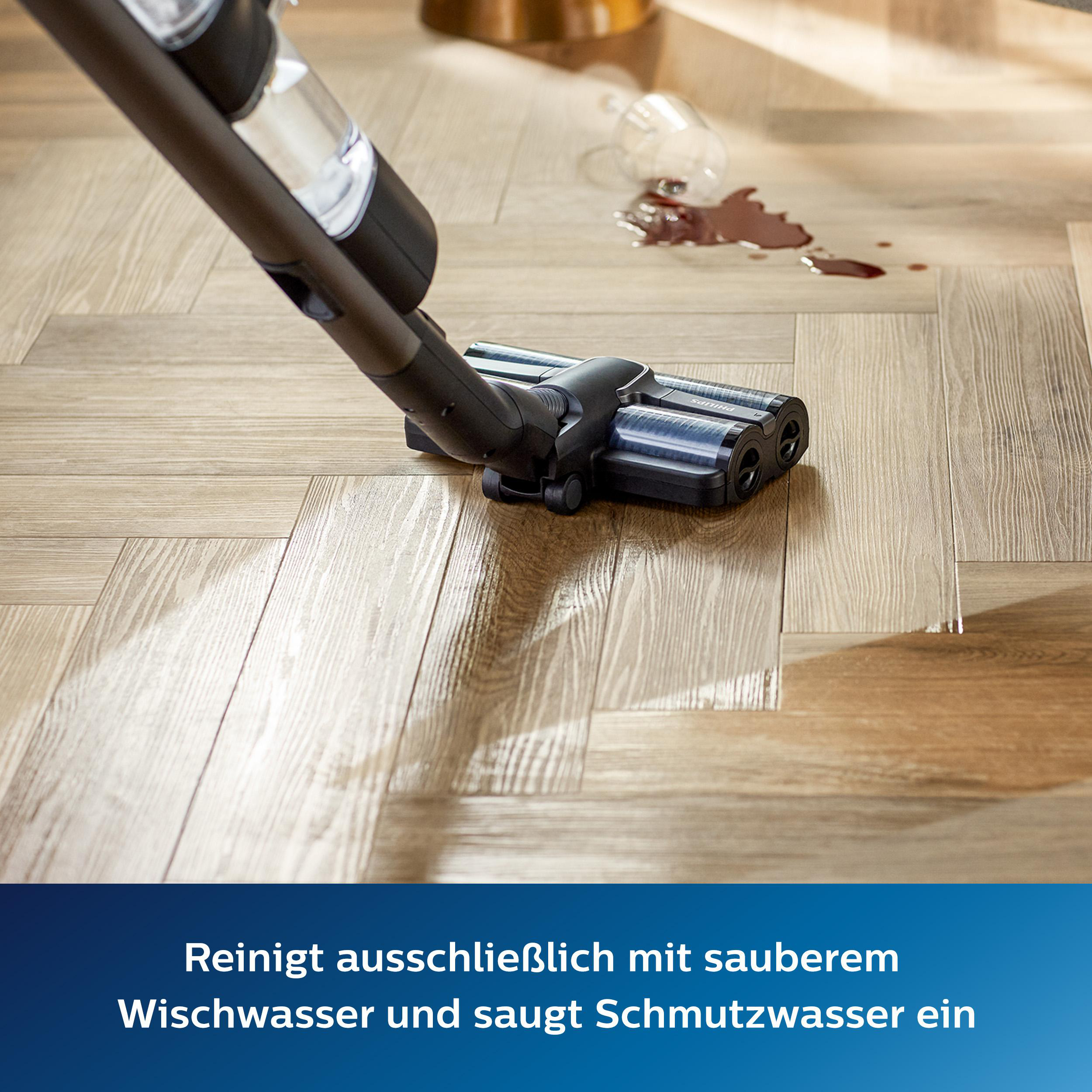 Ein Staubsauger, der eine verschüttete Flüssigkeit auf einem Holzboden aufsaugt.