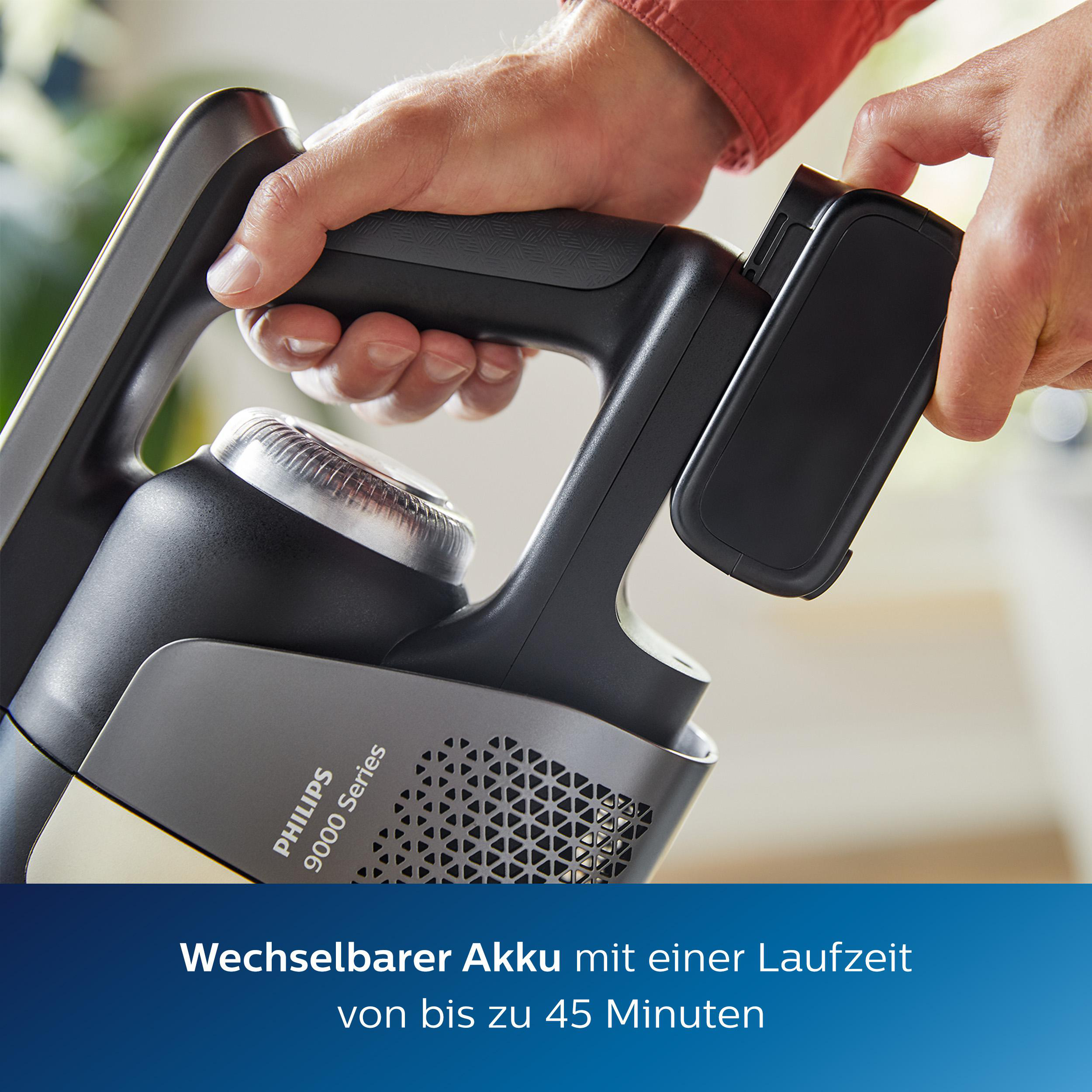 Hände befestigen Akku an schwarzen Staubsauger, Text darunter.