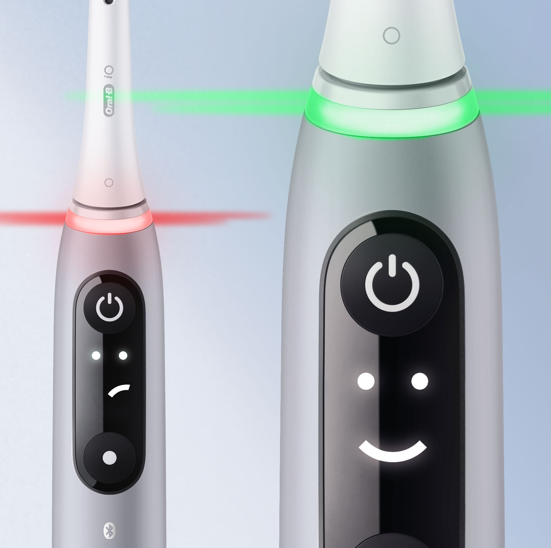 Due spazzolini elettrici con pulsanti di accensione, uno che mostra una faccina sorridente, l'altro una luce rossa.