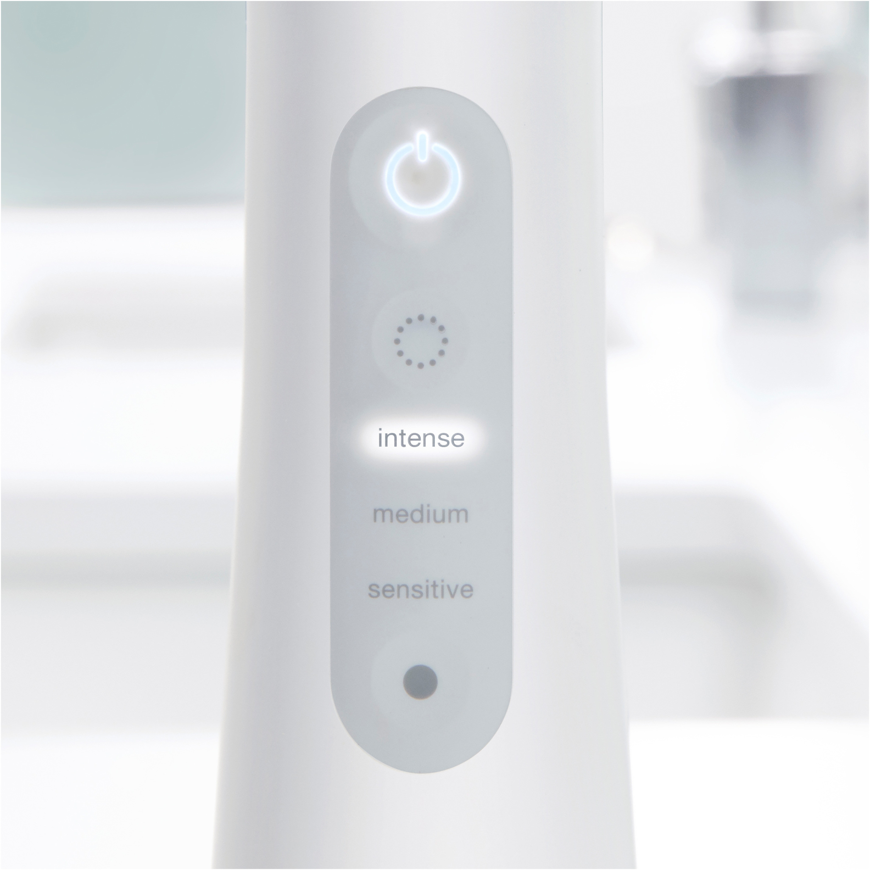 Primo piano di uno spazzolino elettrico bianco con impostazioni illuminate.