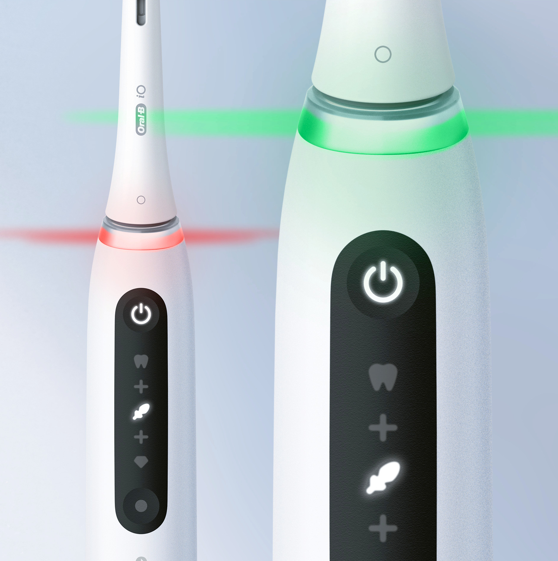 Due spazzolini elettrici, uno bianco, uno nero, entrambi con pulsanti di accensione luminosi.