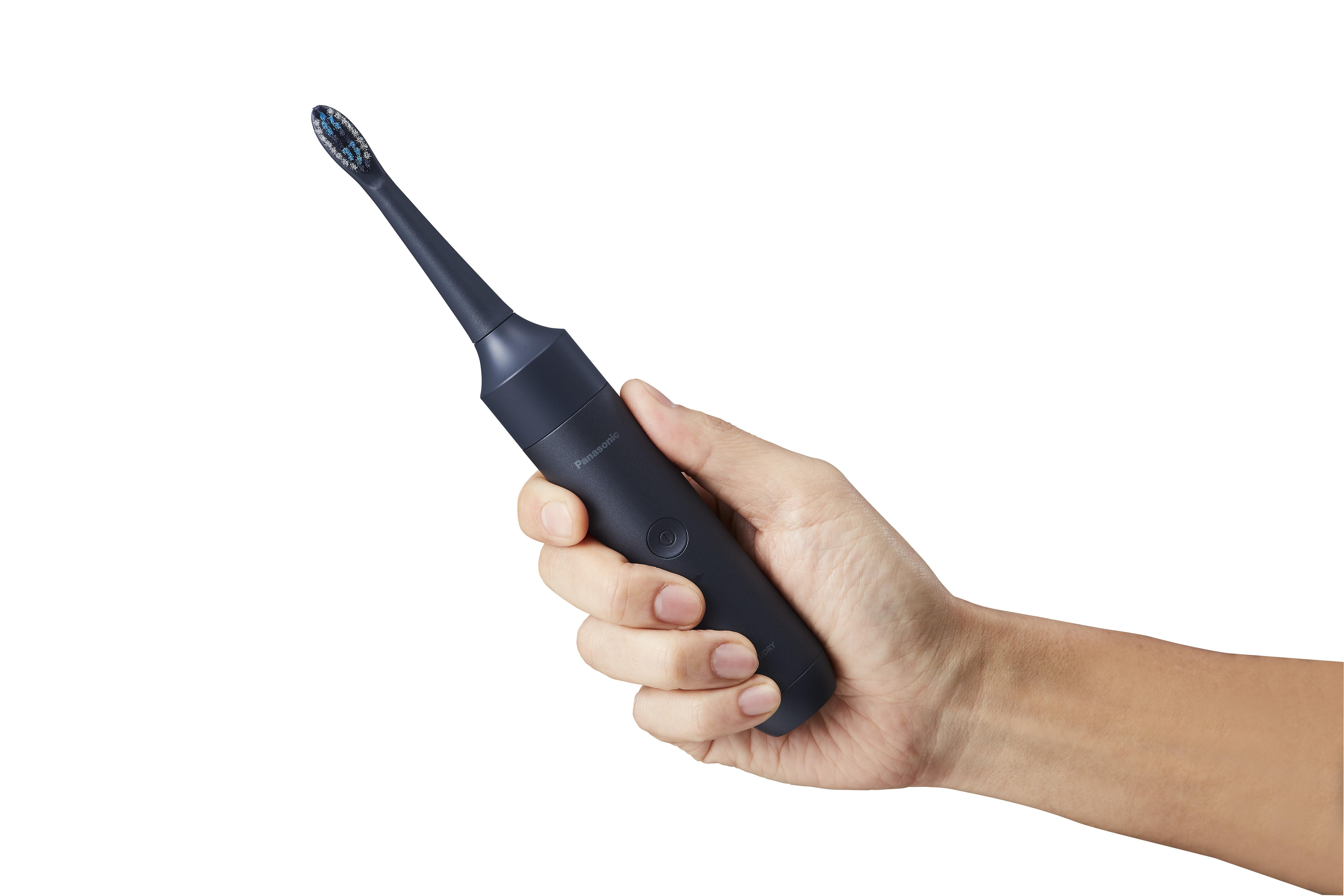 Hand hält dunkelblaue elektrische Zahnbürste. Weißer Hintergrund.
