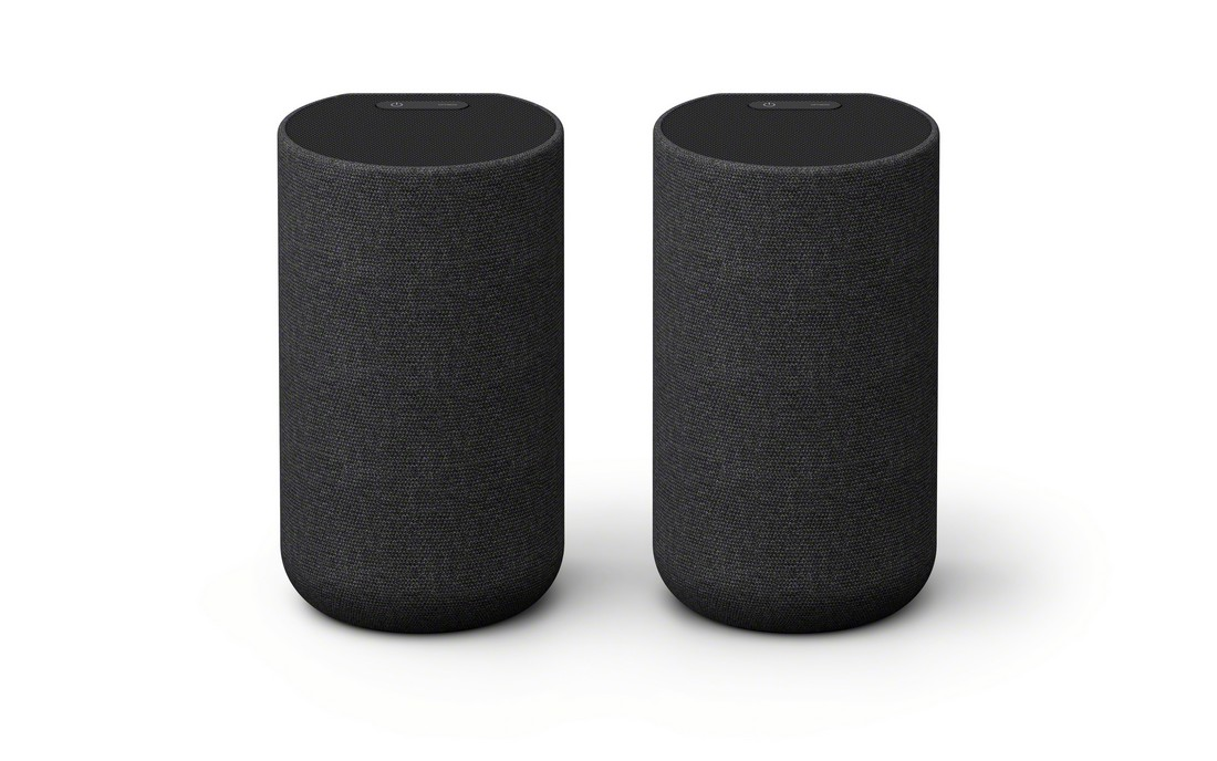 Dos altavoces cilíndricos negros sobre fondo blanco, con botones de encendido en la parte superior.