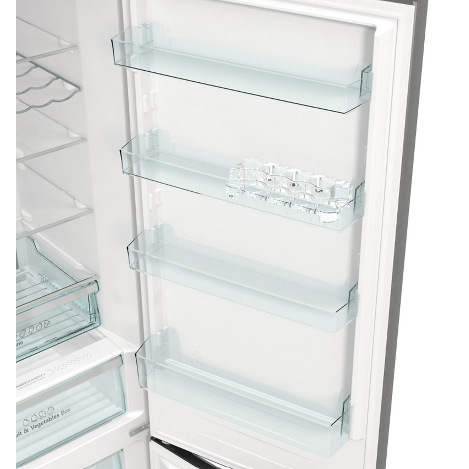 Dentro de un refrigerador con estantes de vidrio. Hay estantes y un cajón para verduras y frutas.